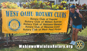 Linda Sato  shows off her club's sign at the Weinberg project work day on Nov. 24.