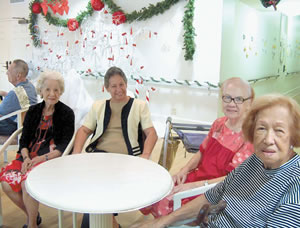 Residents Lily Tom (left), Lydia Mahar and Yvonne Iaela chat with administrator Sister Alicia Damien Lau (center) in the Ohana Room at Lunalilo Home. The Hawaii Kai facility for Hawaiian kupuna hosts a luau later this month to help support its upkeep and programs. Photo by Robert Macanas.