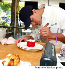 Pastry chef Elijah Frost frosts a red velvet cake