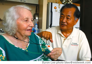 Cullen Hayashida helps Dzidra Damerel with her personal monitoring device