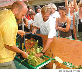 The worm conference crowd gathers round while Gary Seals and Bryan Silver dump waste from lunch and breakfast into the composting bin.