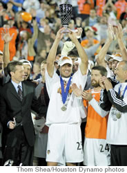 Brian Ching hoists the MLS Cup Most Valuable Player trophy after scoring the tying goal of the game and scoring the winning penalty kick