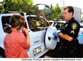 Officer Hamrick talks with a woman after thieves broke into her car