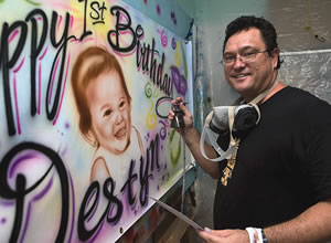 Jeff Pagay works on another birthday banner at Airbrush Creations Hawaii