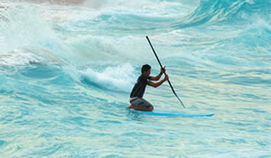 Rusty Keaulana gets down to get through the oncoming waves